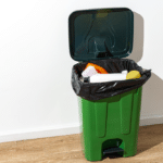 green-plastic-trash-can-full-garbage-indoors